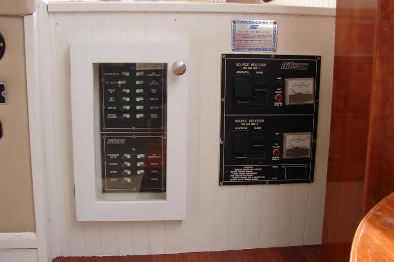 Slide: The Image of Control panel of a 1997 Gibson 47 Sport Houseboat, featuring switches and source selectors. - 57