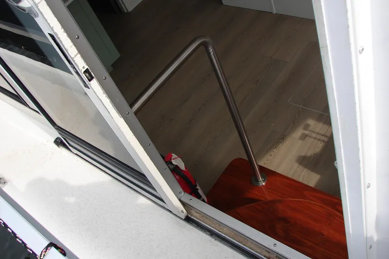 Slide: The Image of Interior view of 1997 Gibson 47 Sport Houseboat with wooden flooring and metal railing. - 58