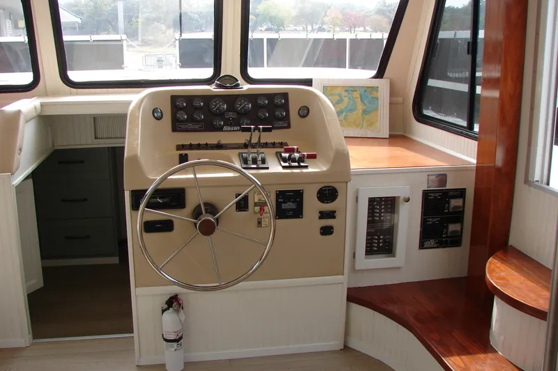 Slide: The Image of 1997 Gibson 47 Sport Houseboat helm with steering wheel and control panel. - 59