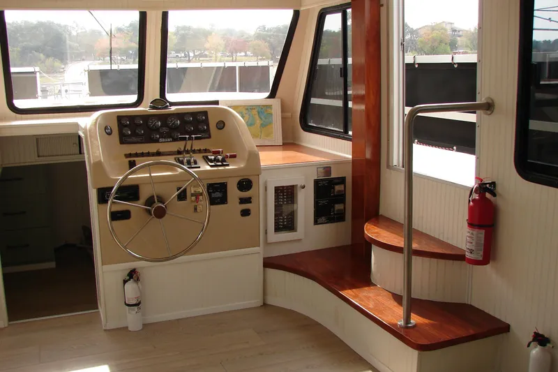 Slide: The Image of 1997 Gibson 47 Sport Houseboat helm with steering wheel and control panel. - 62