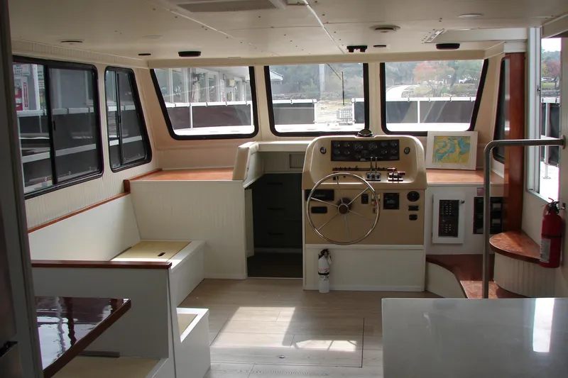 Slide: The Image of Interior of a 1997 Gibson 47 Sport Houseboat with steering wheel and seating area. - 63