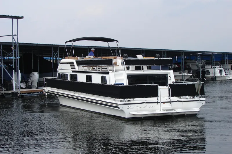 Slide: The Image of 1997 Gibson 47 Sport Houseboat docked at marina, featuring spacious upper deck. - 7