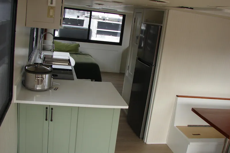 Slide: The Image of Interior of a 1997 Gibson 47 Sport Houseboat with kitchen and sleeping area. - 79