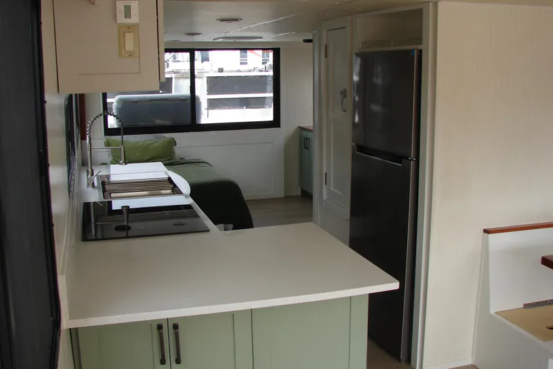 Slide: The Image of Interior of a 1997 Gibson 47 Sport Houseboat with modern kitchen and cozy sleeping area. - 86