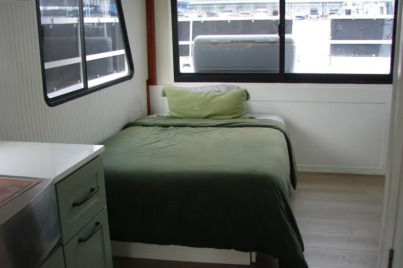 Slide: The Image of Cozy bedroom in 1997 Gibson 47 Sport Houseboat with green bedding and large windows. - 89