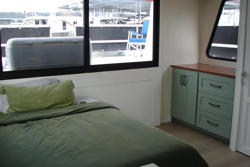Slide: The Image of Cozy bedroom interior of 1997 Gibson 47 Sport Houseboat with green bedding and cabinets. - 91