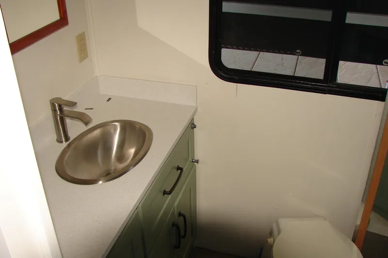 Slide: The Image of Bathroom interior of 1997 Gibson 47 Sport Houseboat with sink and window. - 94