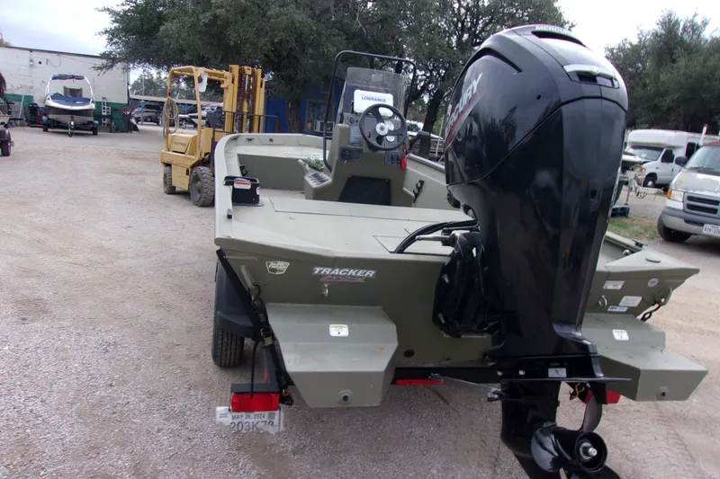 Slide: The Image of 2024 Tracker Grizzly 1860 CC boat with Mercury outboard motor, parked outdoors. - 3