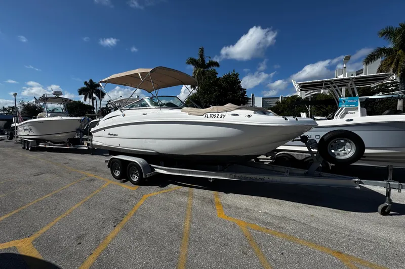 The Image of 2021 Hurricane SunDeck 2200 DC OB boat on trailer under clear blue sky. - 11