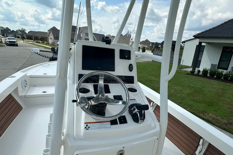 Slide: The Image of Pathfinder 2500 Hybrid 2021 boat console with steering wheel and controls, parked in residential area. - 10