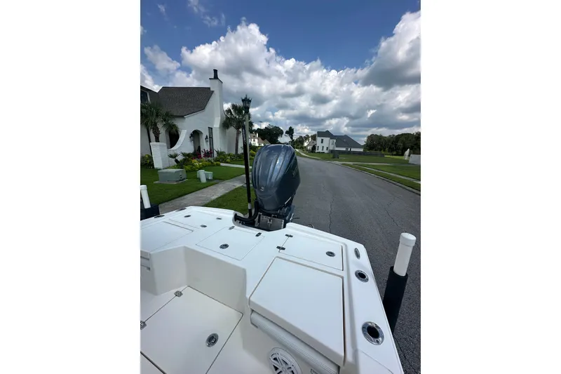 Slide: The Image of 2021 Pathfinder 2500 Hybrid boat on residential street under cloudy sky. - 13