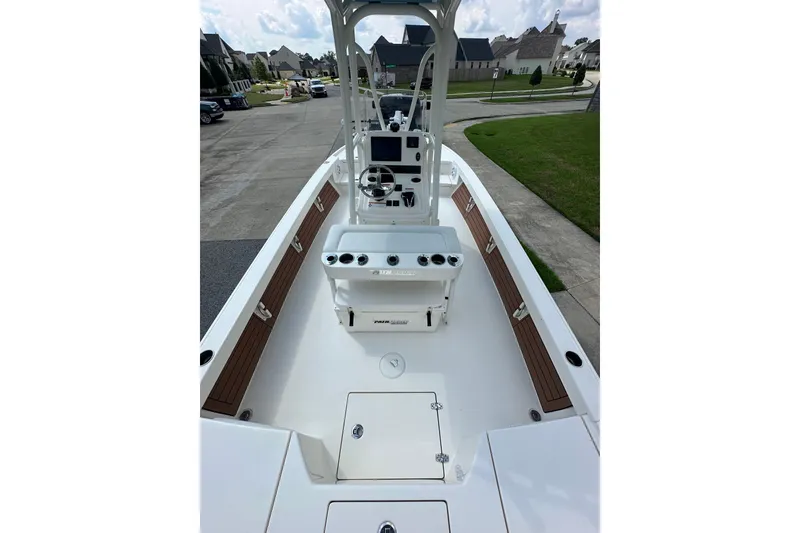 Slide: The Image of 2021 Pathfinder 2500 Hybrid boat interior with console and seating, parked in a residential area. - 14
