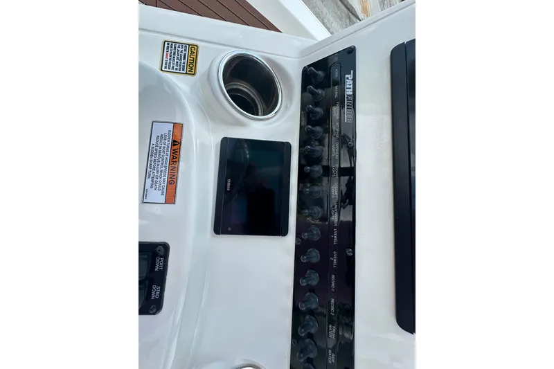 Slide: The Image of 2021 Pathfinder 2500 Hybrid boat dashboard with controls and warning labels. - 18