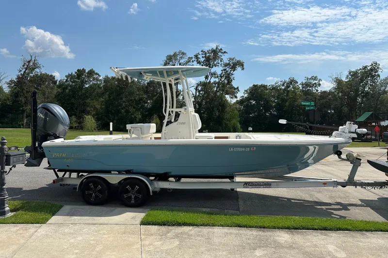 Slide: The Image of 2021 Pathfinder 2500 Hybrid boat on trailer, parked outdoors under a clear sky. - 5