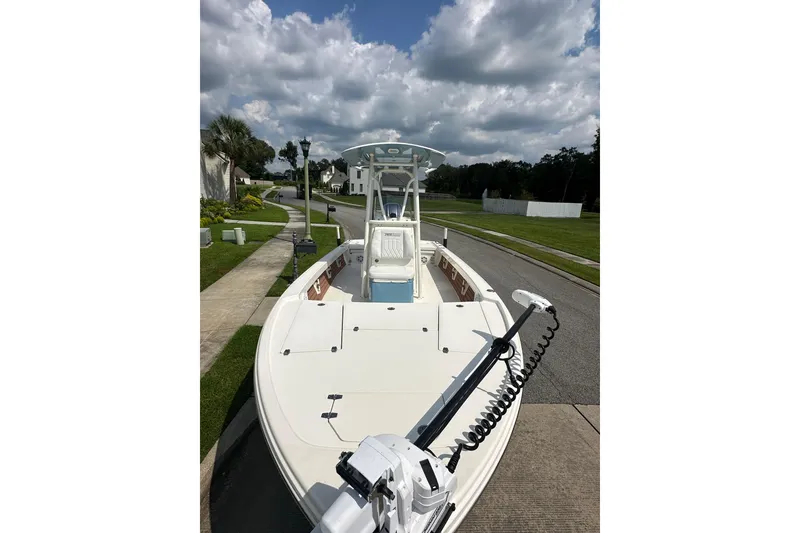 Slide: The Image of 2021 Pathfinder 2500 Hybrid boat on a residential street under cloudy skies. - 8