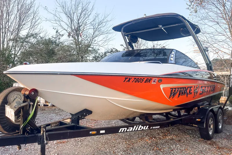 Slide: The Image of 2011 Malibu Wakesetter 21 VLX boat on trailer, vibrant orange design. - 5