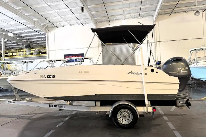 The Image of 2019 Hurricane SunDeck Sport 188 OB boat on trailer in indoor storage. - 0