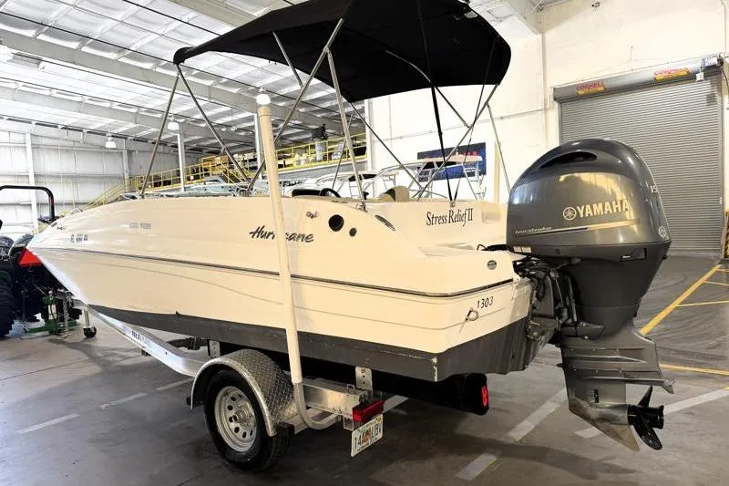 Slide: The Image of 2019 Hurricane SunDeck Sport 188 OB boat with Yamaha outboard motor in a warehouse. - 2