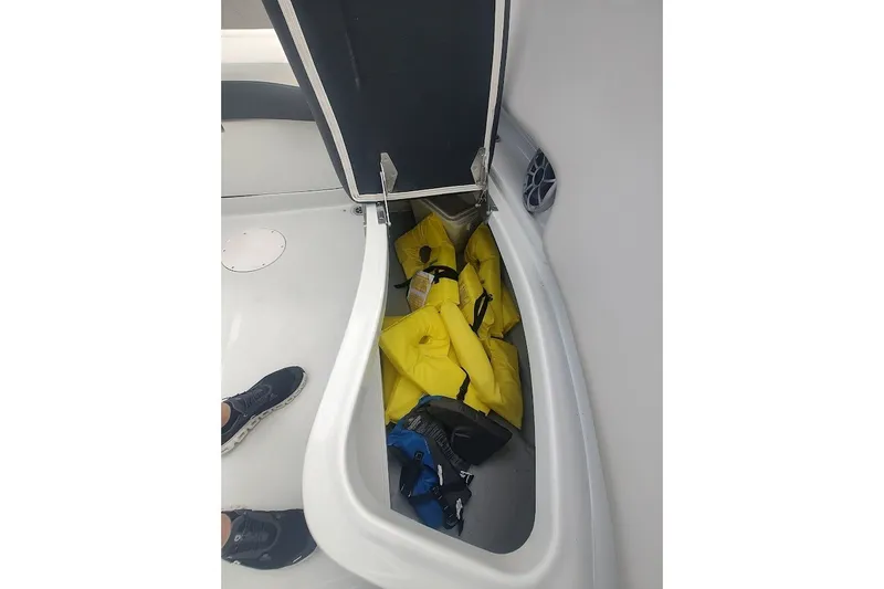 Slide: The Image of Open storage compartment on 2022 Crownline 280 SS boat with life jackets inside. - 15