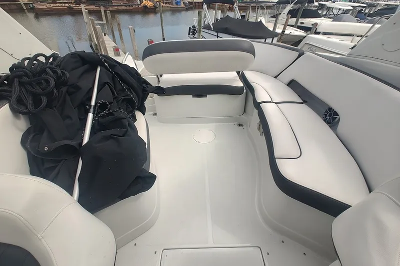 Slide: The Image of 2022 Crownline 280 SS boat interior with white seating and dock view. - 17