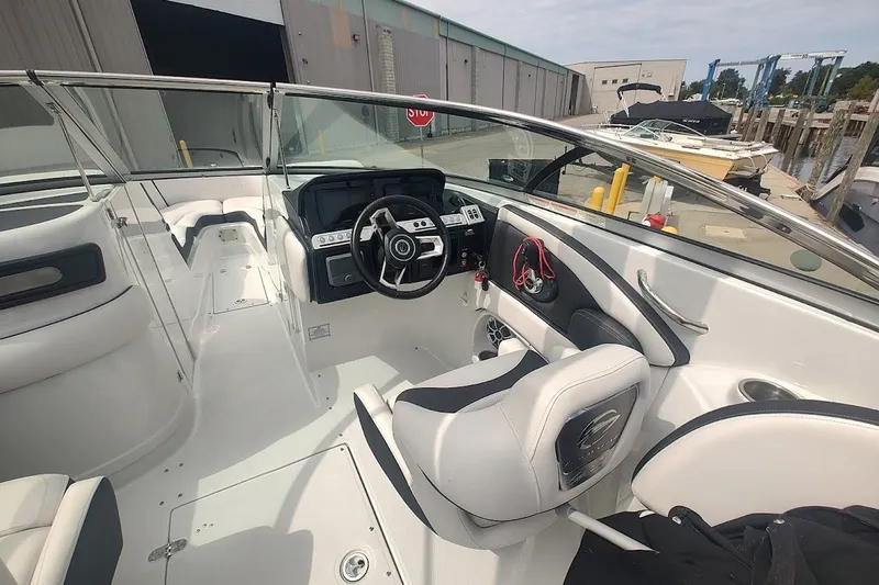 Slide: The Image of Interior view of a 2022 Crownline 280 SS boat, showcasing steering and seating area. - 23