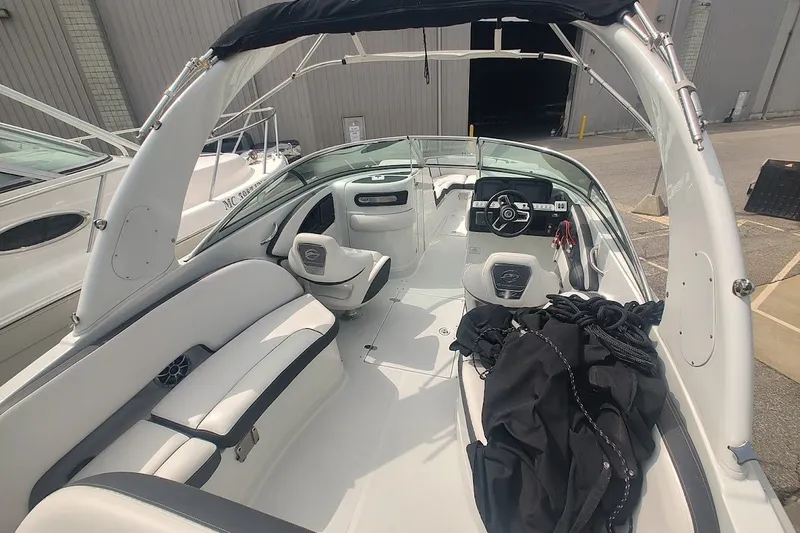 Slide: The Image of 2022 Crownline 280 SS boat interior with white seating and steering console. - 24