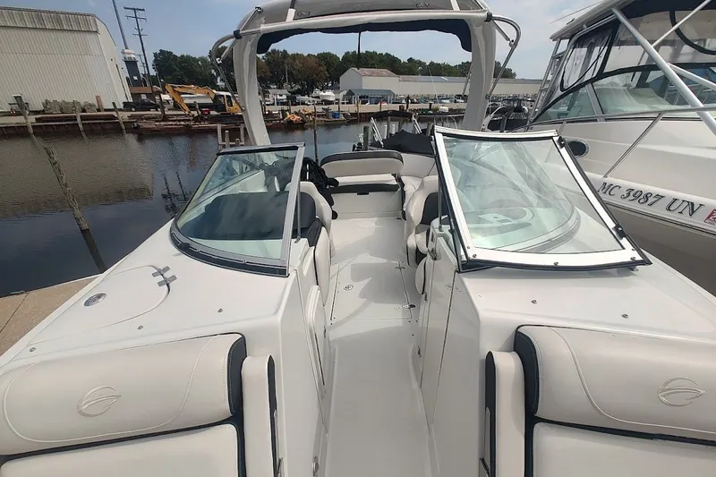 Slide: The Image of 2022 Crownline 280 SS boat docked at marina, showcasing sleek design and spacious seating. - 19