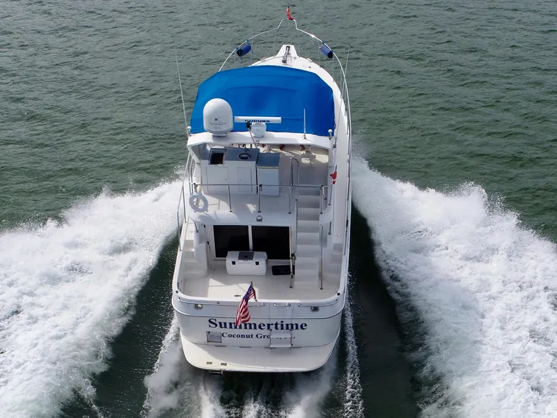 Slide: The Image of Ocean Alexander Atlus 48 yacht cruising on water, rear view, blue canopy, American flag. - 5