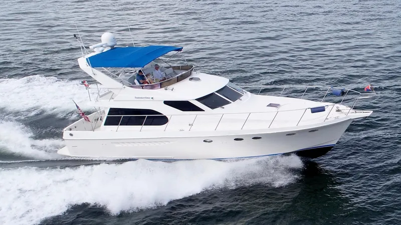 The Image of 2004 Ocean Alexander Atlus 48 yacht cruising on open water with blue canopy. - 0