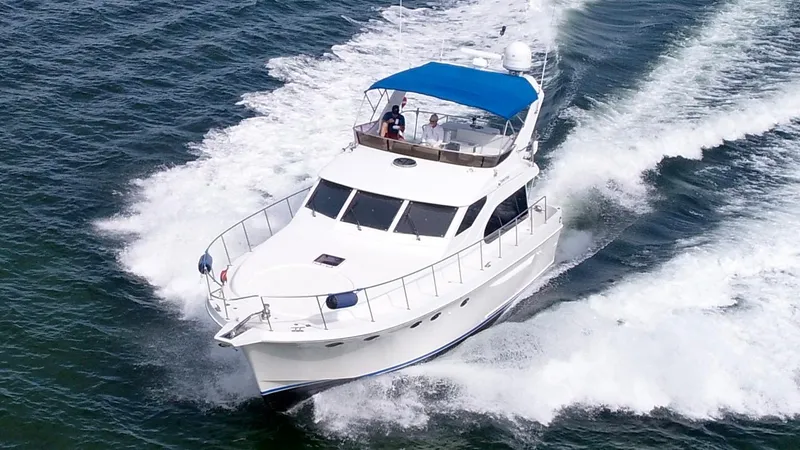 Slide: The Image of 2004 Ocean Alexander Atlus 48 yacht cruising on open water with blue canopy. - 4