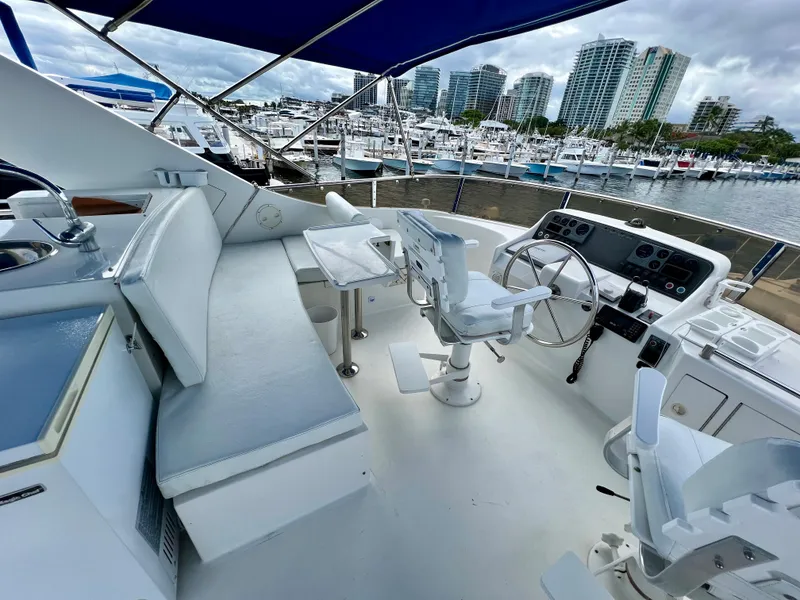 Slide: The Image of 2004 Ocean Alexander Atlus 48 yacht helm with marina view, featuring modern controls and seating. - 6
