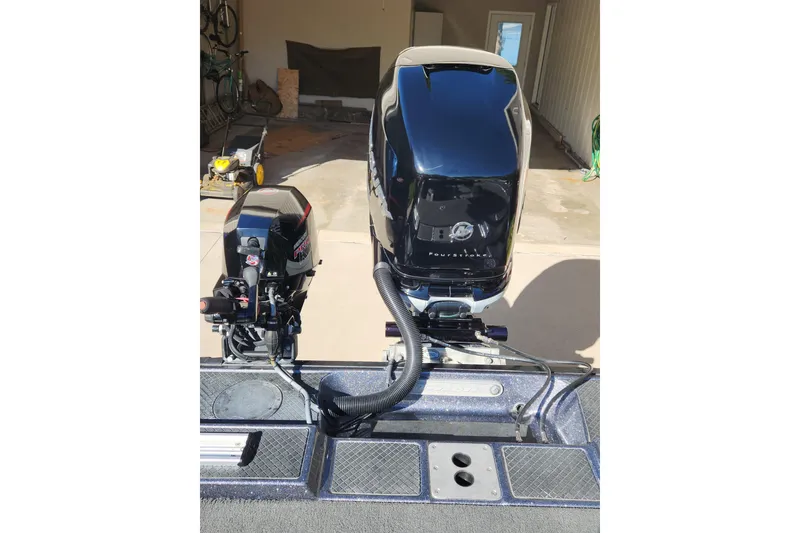 Slide: The Image of 2017 Triton 216 Fishunter boat with dual outboard motors in a garage setting. - 10