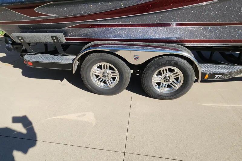 Slide: The Image of 2017 Triton 216 Fishunter boat trailer with dual wheels on a concrete surface. - 14