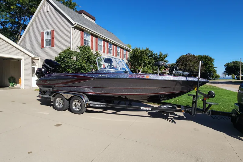 Slide: The Image of 2017 Triton 216 Fishunter boat on trailer, parked in driveway near house. - 3