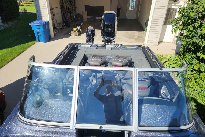 Slide: The Image of 2017 Triton 216 Fishunter boat parked in driveway, featuring windshield and seating. - 7