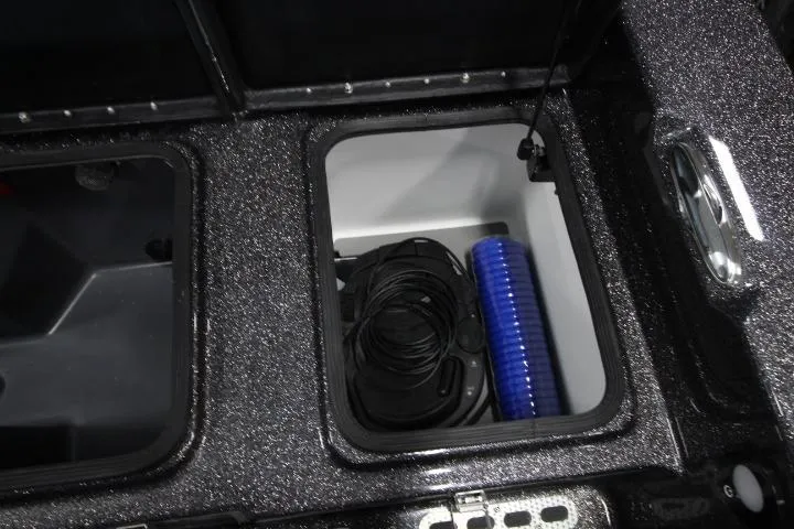 Slide: The Image of Storage compartment of 2026 Yar-Craft 210 TFX boat with coiled cables and blue hose. - 11