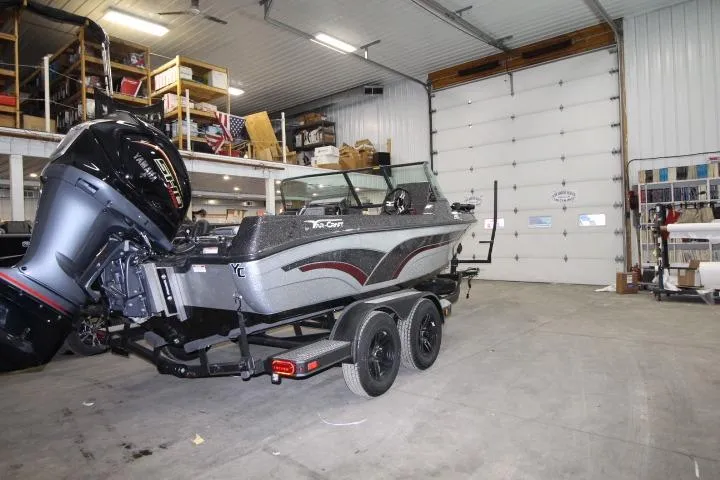 Slide: The Image of 2026 Yar-Craft 210 TFX boat in a garage, featuring a powerful outboard motor. - 4