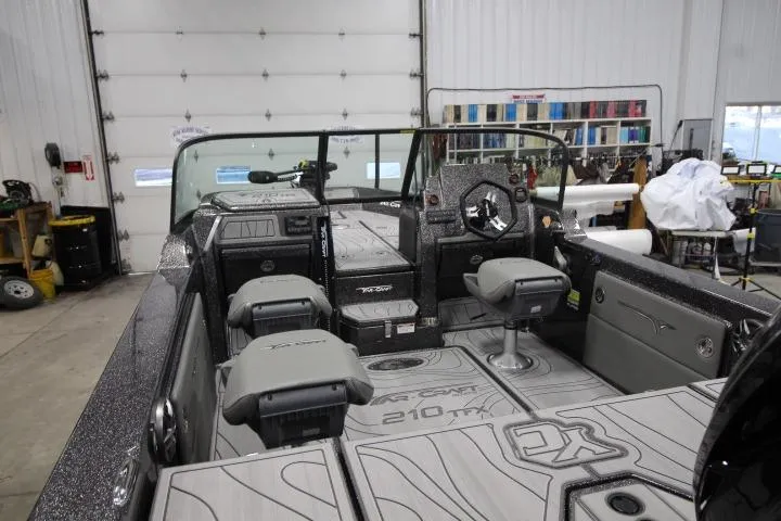 Slide: The Image of 2026 Yar-Craft 210 TFX boat interior with seating and dashboard in a garage setting. - 5
