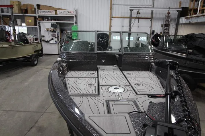 Slide: The Image of 2026 Yar-Craft 210 TFX boat in a showroom, featuring sleek design and spacious deck. - 6