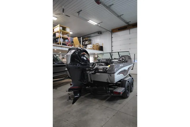 Slide: The Image of 2026 Yar-Craft 210 TFX boat in a garage, featuring a powerful outboard motor. - 7