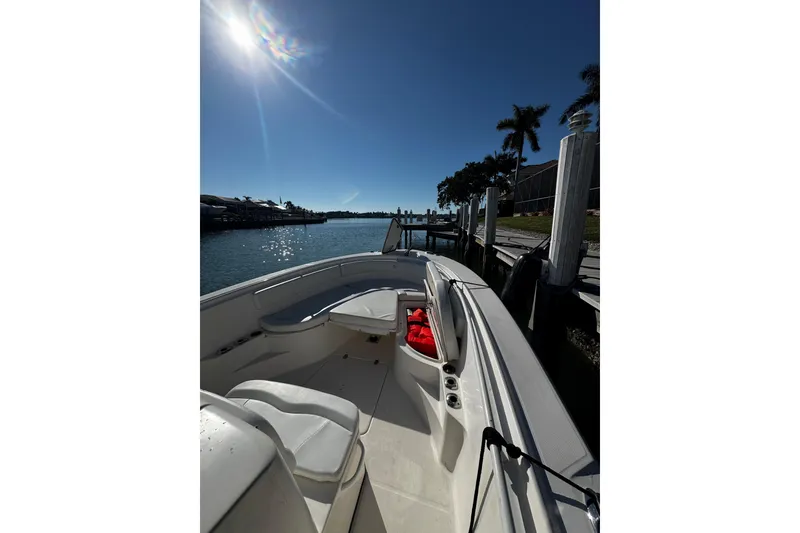 Slide: The Image of 2015 Edgewater 320CC boat docked under sunny skies with palm trees. - 10