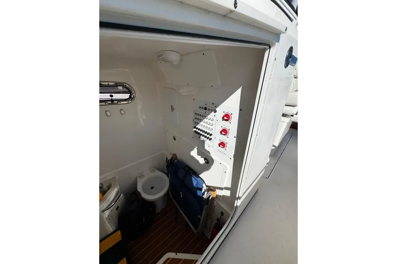 Slide: The Image of Interior of 2015 Edgewater 320CC boat showing control panel and compact toilet. - 14