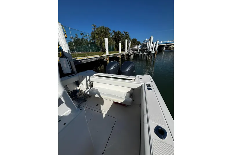 Slide: The Image of 2015 Edgewater 320CC boat docked, featuring dual outboard motors and spacious deck. - 15
