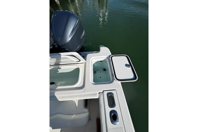 Slide: The Image of 2015 Edgewater 320CC boat with open storage compartments and Yamaha outboard motor. - 16