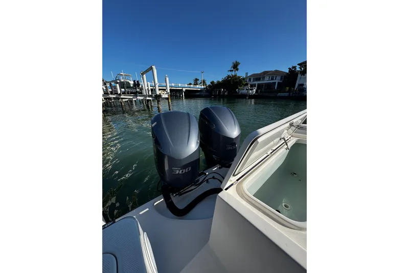 Slide: The Image of 2015 Edgewater 320CC boat with dual 300 horsepower engines docked by waterfront homes. - 18