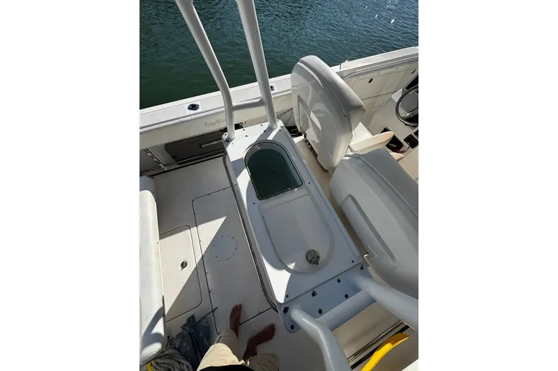 Slide: The Image of 2015 Edgewater 320CC boat interior with seating and storage, docked on water. - 20