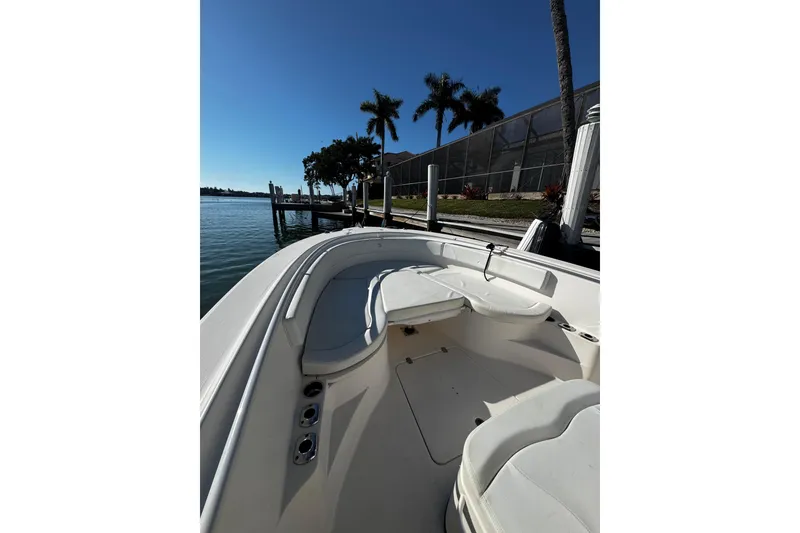 Slide: The Image of 2015 Edgewater 320CC boat docked by palm trees and waterfront. - 29