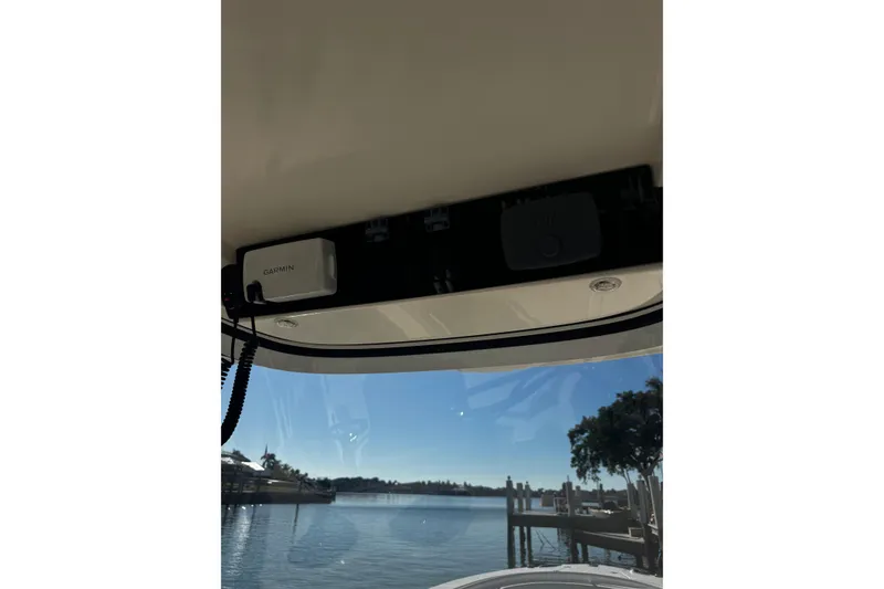 Slide: The Image of 2015 Edgewater 320CC boat interior with Garmin device, overlooking a serene waterfront. - 31