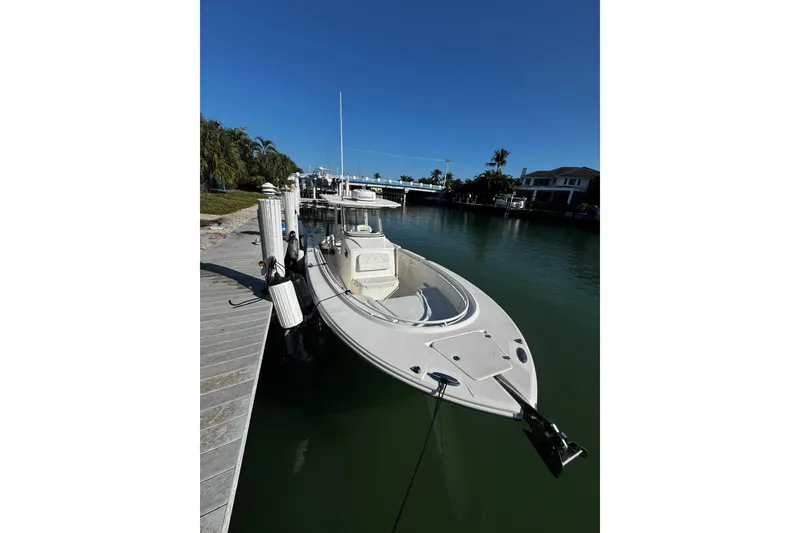 Slide: The Image of 2015 Edgewater 320CC boat docked in a serene waterfront setting. - 32