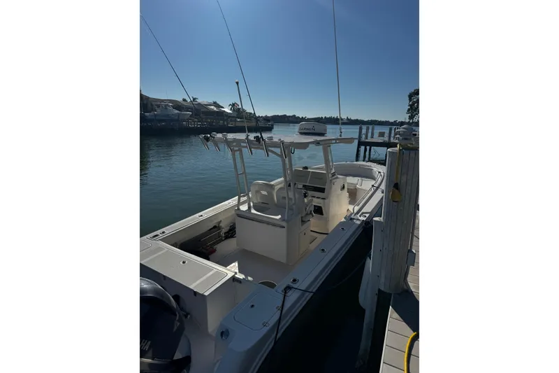 Slide: The Image of 2015 Edgewater 320CC boat docked by a serene waterfront. - 33